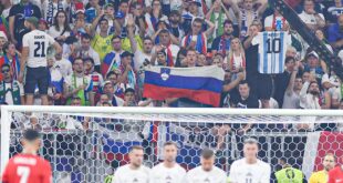 Slovenia fan holds up Messi shirt as Ronaldo takes free kick