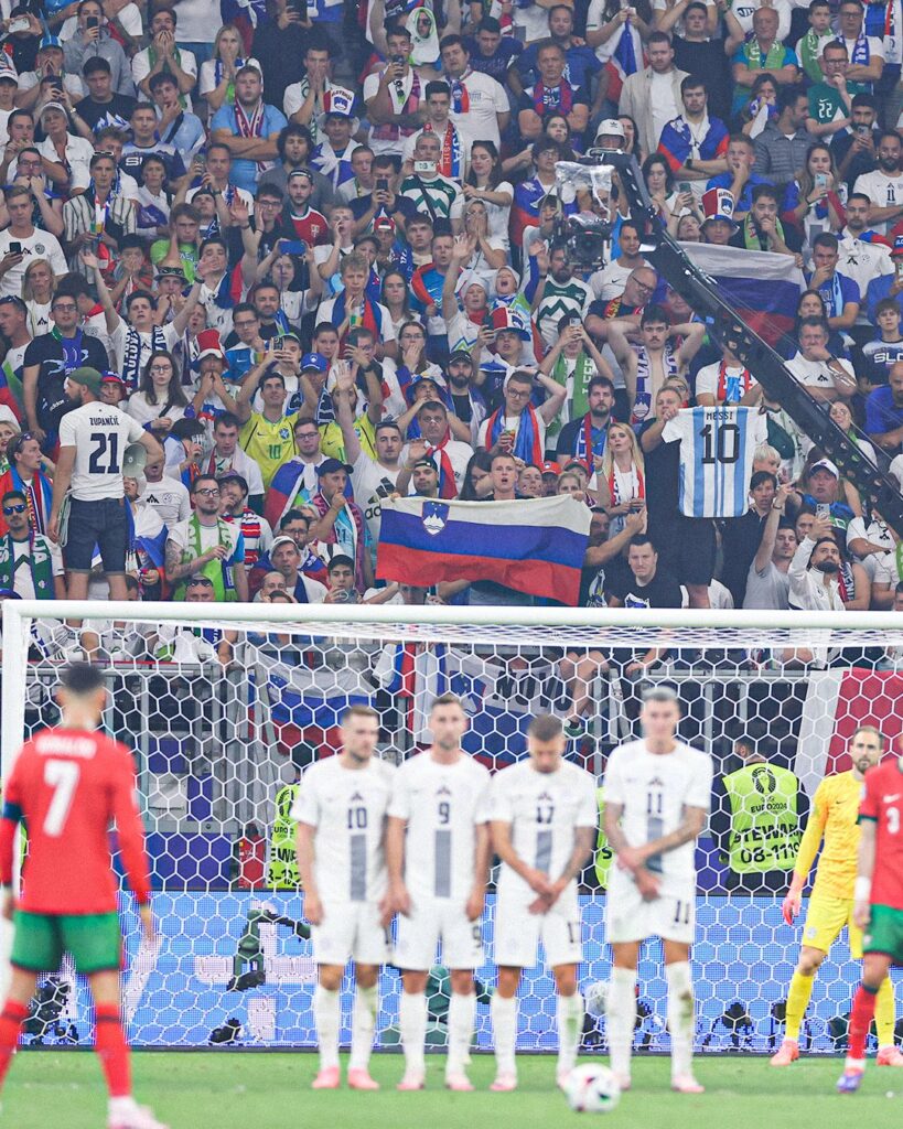 Slovenia fan holds up Messi shirt as Ronaldo takes free kick